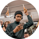 Uma pessoa em um metro ou ônibus observando algo no celular